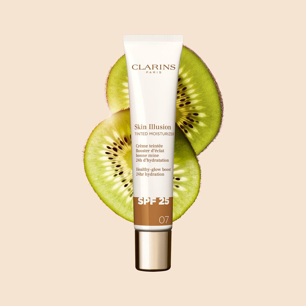 Packshot of the 40ml tube of Skin perfector Skin Illusion Tinted Moisturiser shade 07 placed next to kiwi slides