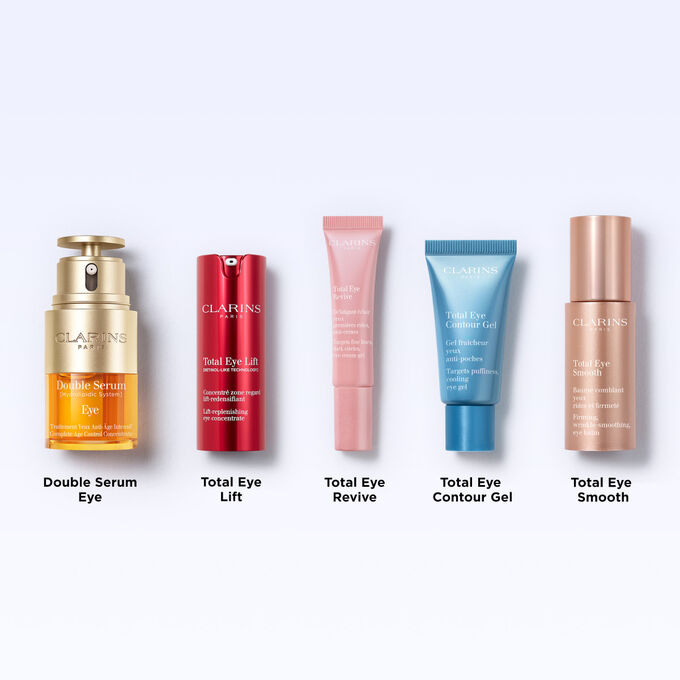 Tube of Clarins Total Eye Contour Gel among coffee seeds to illustrate the natural origin of the product's ingredients.