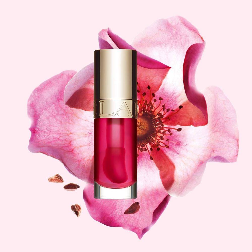 Clarins Lip Comfort Oil 04 Pitaya with skincare benefits, in front of a Sweetbriar rose to highlight its natural ingredients.