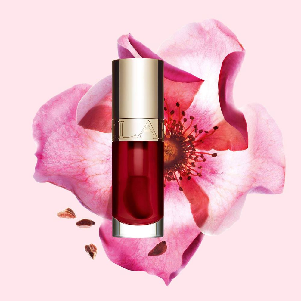 Clarins Lip Comfort Oil 03 Cherry with skincare benefits, in front of a Sweetbriar rose to highlight its natural ingredients.