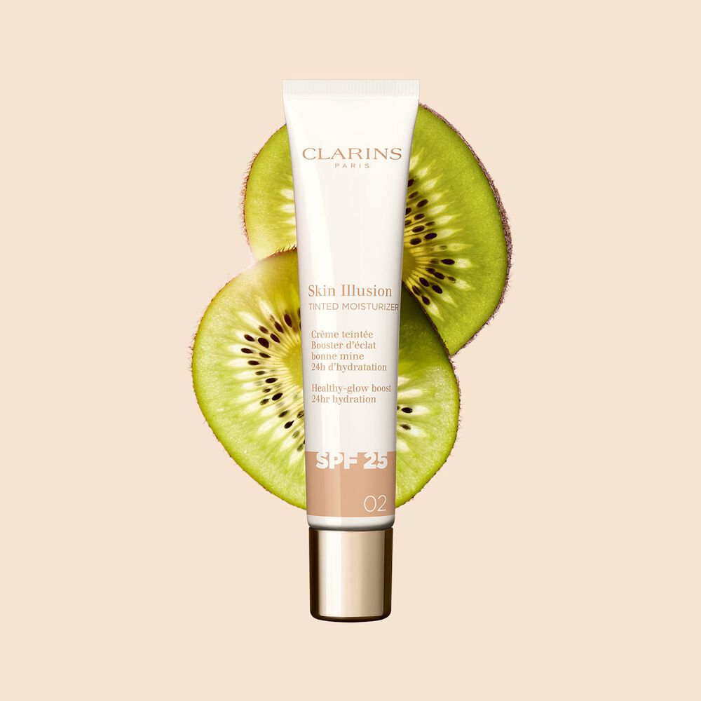 Packshot of the 40ml tube of Skin perfector Skin Illusion Tinted Moisturiser shade 02 placed next to kiwi slides