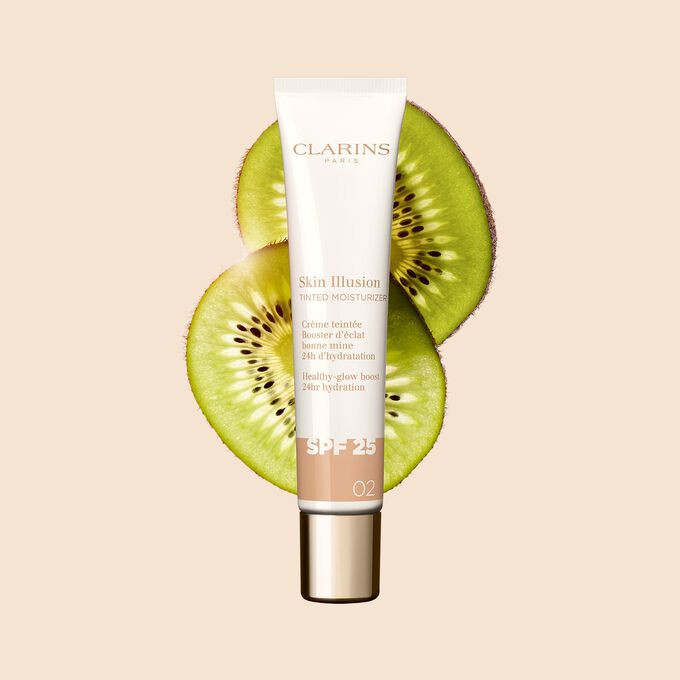 Packshot of the 40ml tube of Skin perfector Skin Illusion Tinted Moisturiser shade 02 placed next to kiwi slides