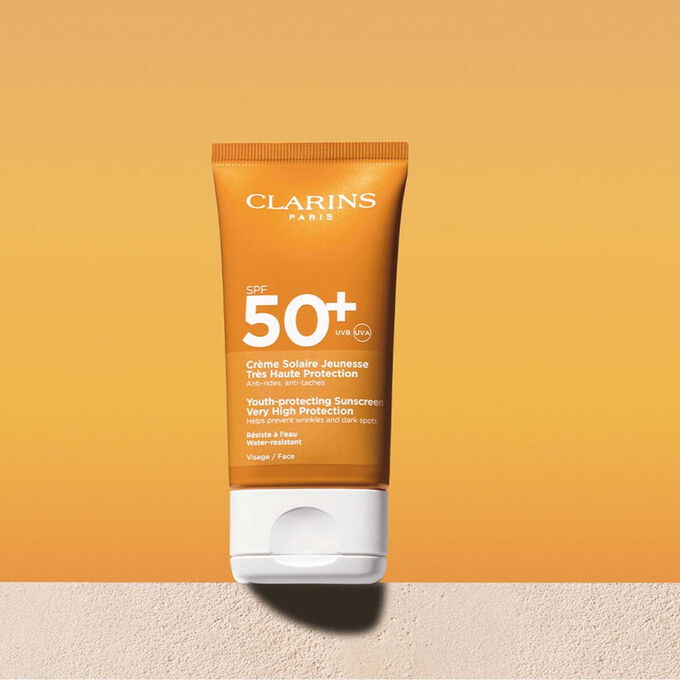 Packshot of a facial sun cream factor 50 tube with a message announcing that Clarins is committed to environmental protection