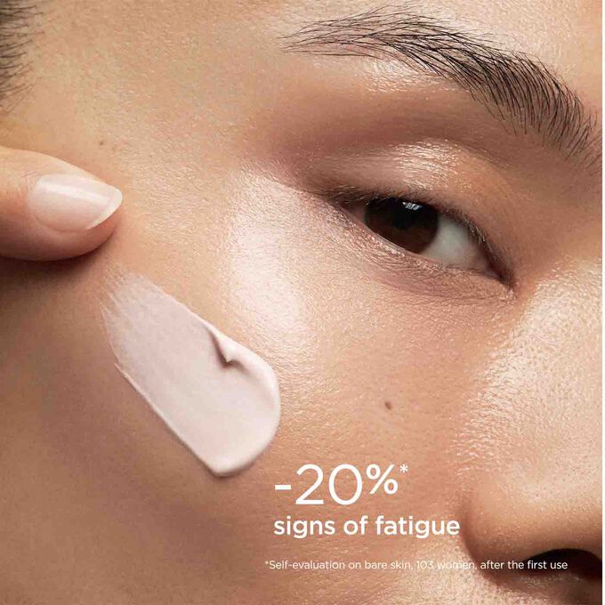 Woman wearing SOS Primer Pink by Clarins to illustrate that it reduces signs of fatigue by 20%.