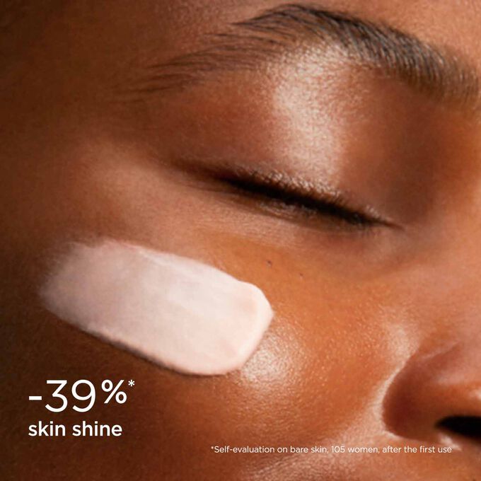 Woman wearing SOS Primer Mattifying by Clarins to illustrate that it reduces skin shine by 39%.