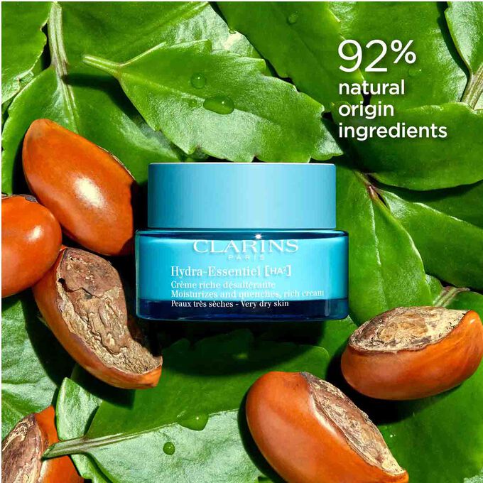 Packshot of Clarins Hydra-Essentiel 23 Rich Cream among leaves and shea nuts, highlighting its 92% natural origin ingredients