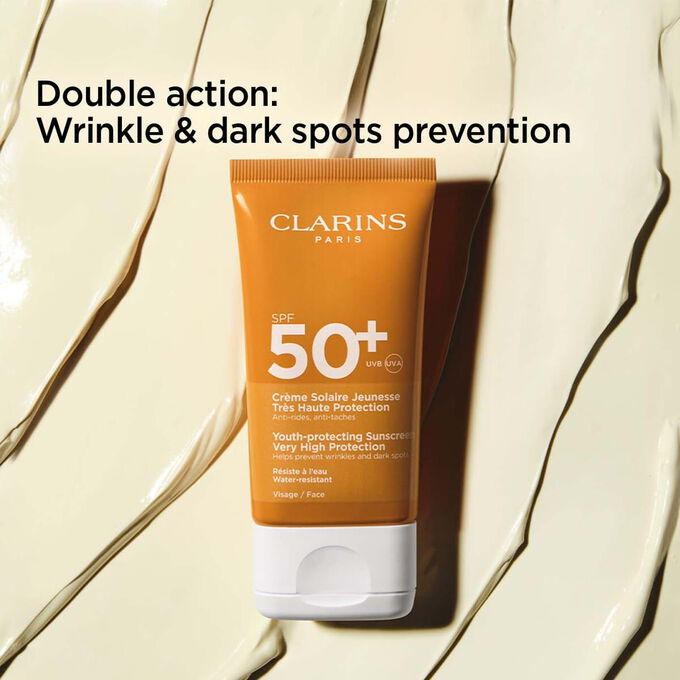 Packshot on textured background of anti-age cream 50+ tube with text about its anti-wrinkles and dark spots prevention actions