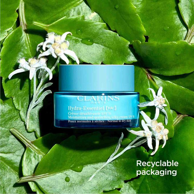 Packshot of Clarins Hydra-Essentiel SPF15 among leaves and edelweiss flowers with text emphasising its recyclable packaging.