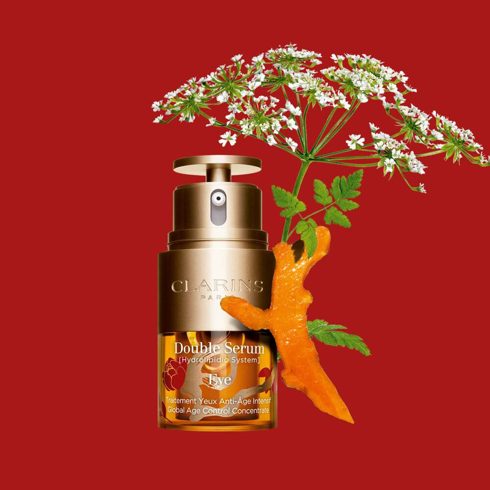 Packshot of Clarins Eye Double Serum Chinese New Year Limited Edition, placed next to a turmeric slice and a wild chervil flower.