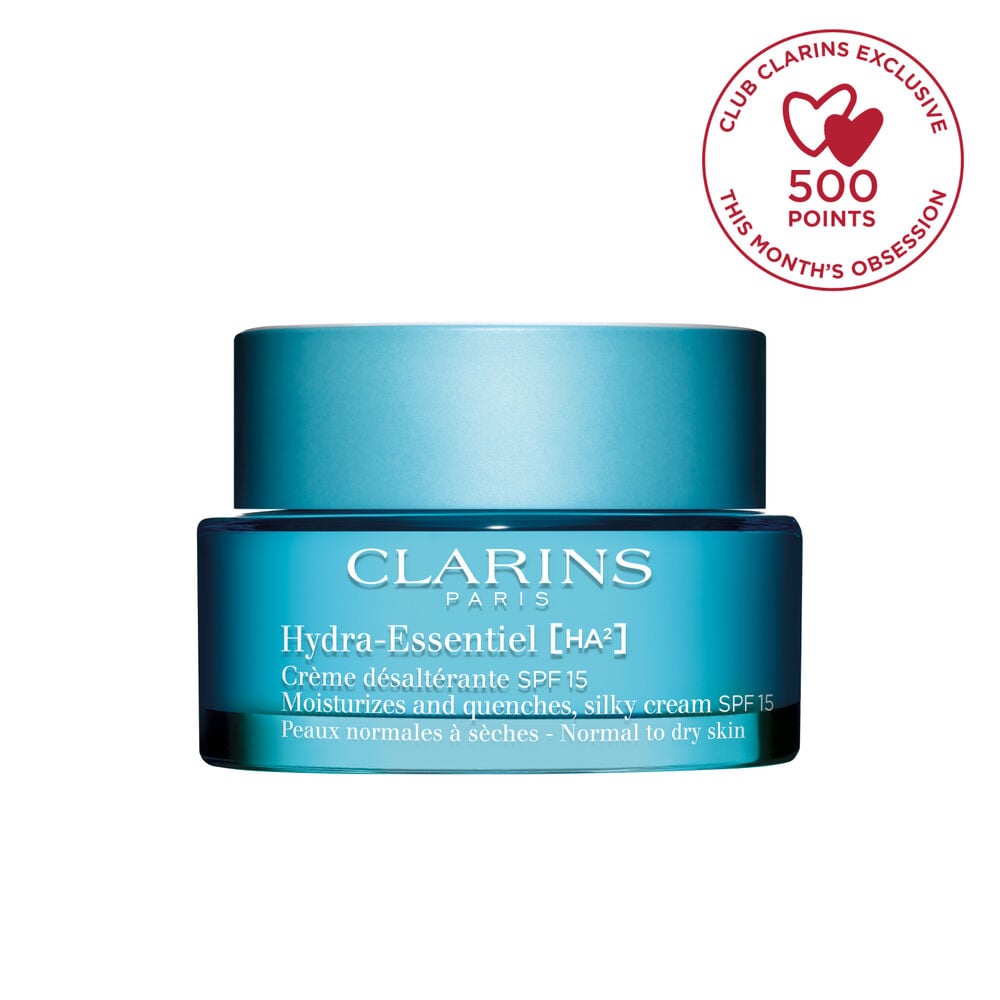 Packshot of Clarins Hydra-Essentiel SPF15 close to some edelweiss flowers on a blue background.