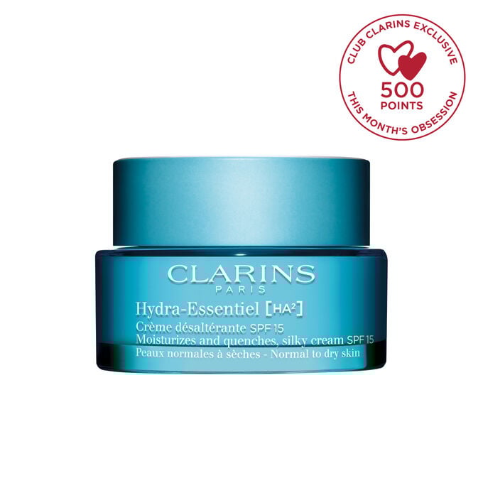 Packshot of Clarins Hydra-Essentiel SPF15 close to some edelweiss flowers on a blue background.