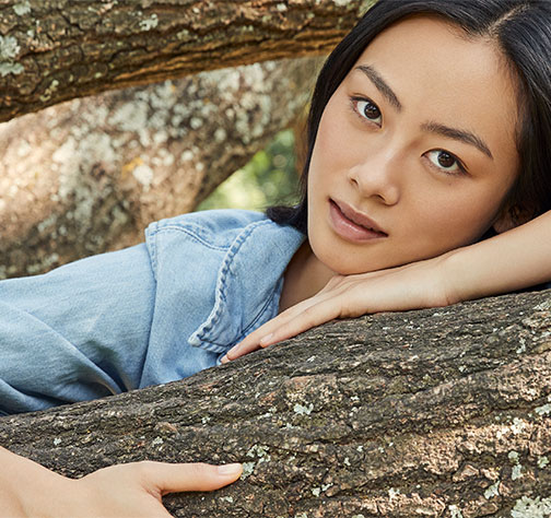 A woman leaning on a branch