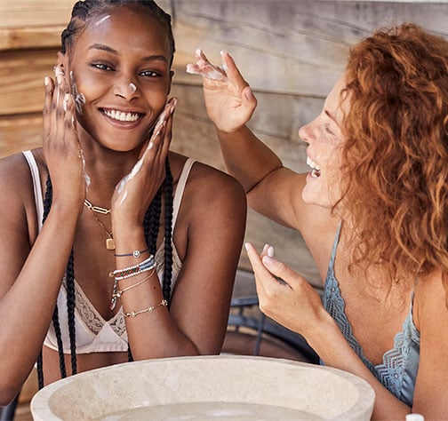 Two people applying the hydrating cream