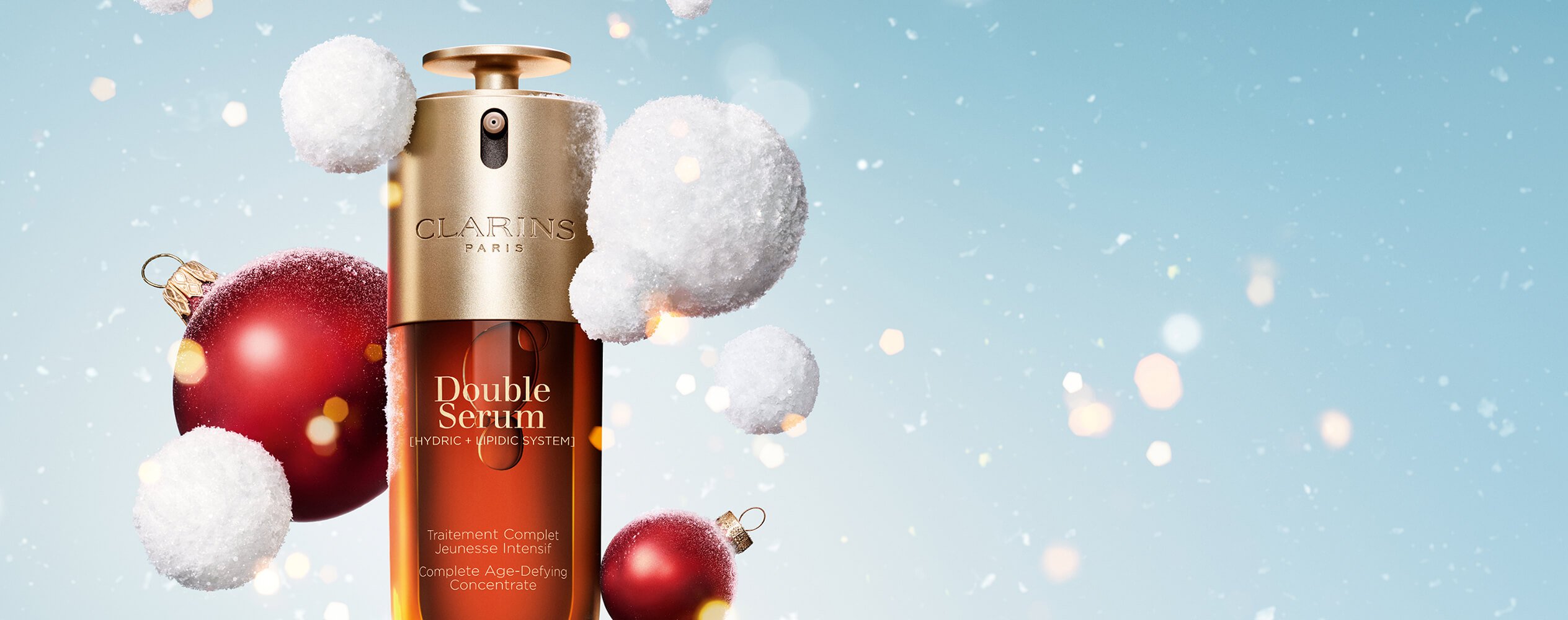 Double serum on a snowy Christmas background with snowballs and red Christmas baubles