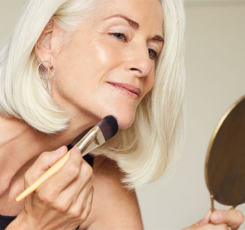 A woman applying foundation with a brush