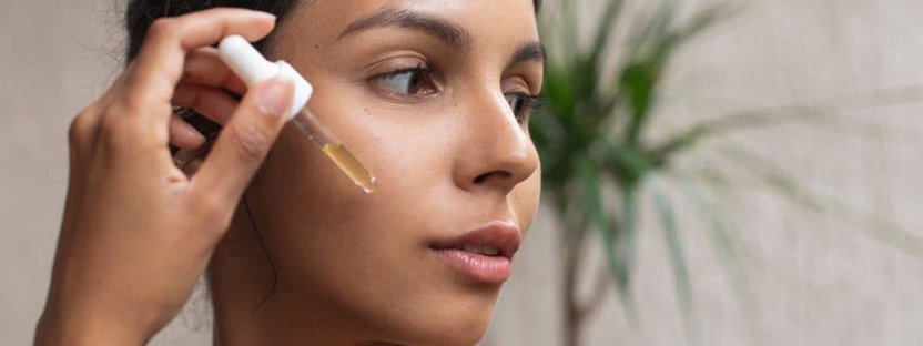 A woman applying serum on her face A woman applying serum on her face