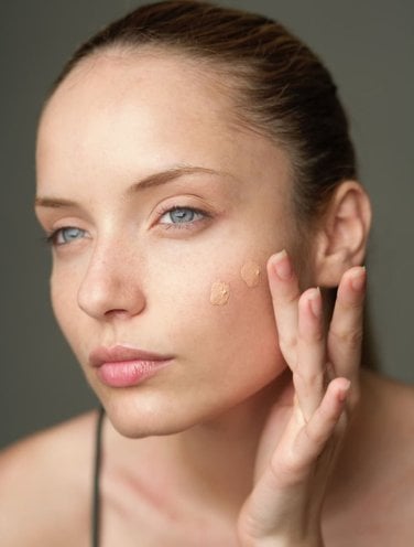Woman putting on concealer. Woman putting on concealer.