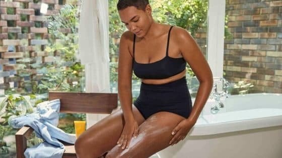 A woman applying body moituriser A woman applying body moituriser